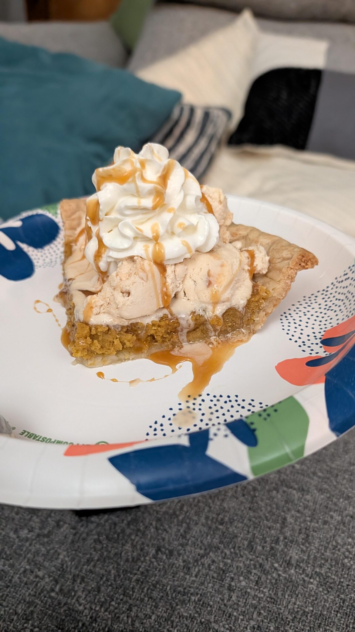 Homemade pumpkin pie with caramel ice cream and whipped cream topped with caramel syrup