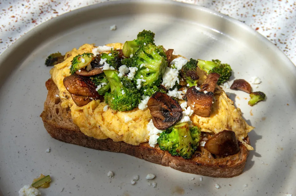 Plate of tostada de la huerta (scrambled eggs,feta cheese, mushrooms and broccoli on toasted sourdough bread)