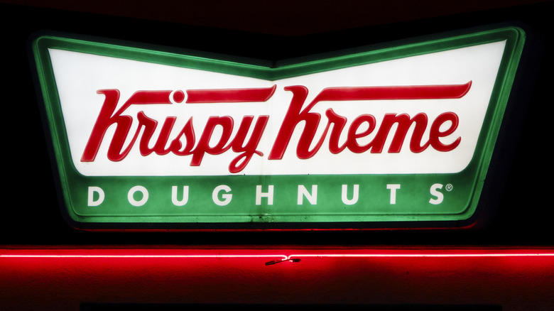 Neon Krispy Kreme Donuts sign against night sky