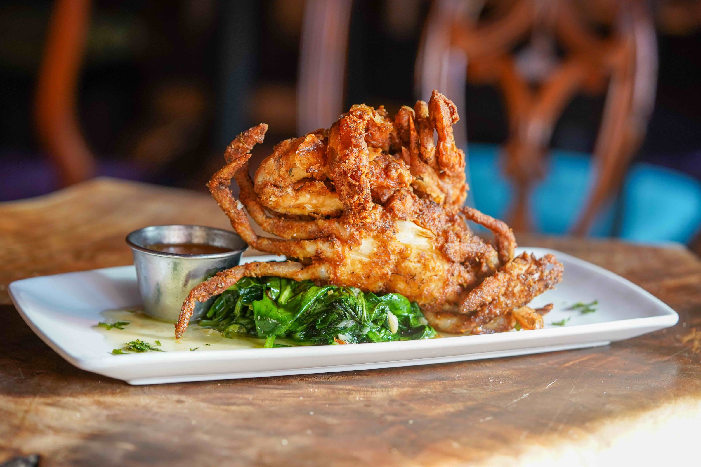 plate with greens and two soft shell fried crabs
