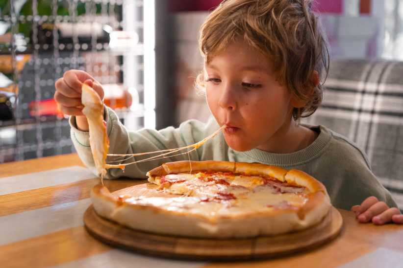 Cute boy eating a piece of pizza, Yelp  Top 100 Places to Eat, best places to eat in nyc