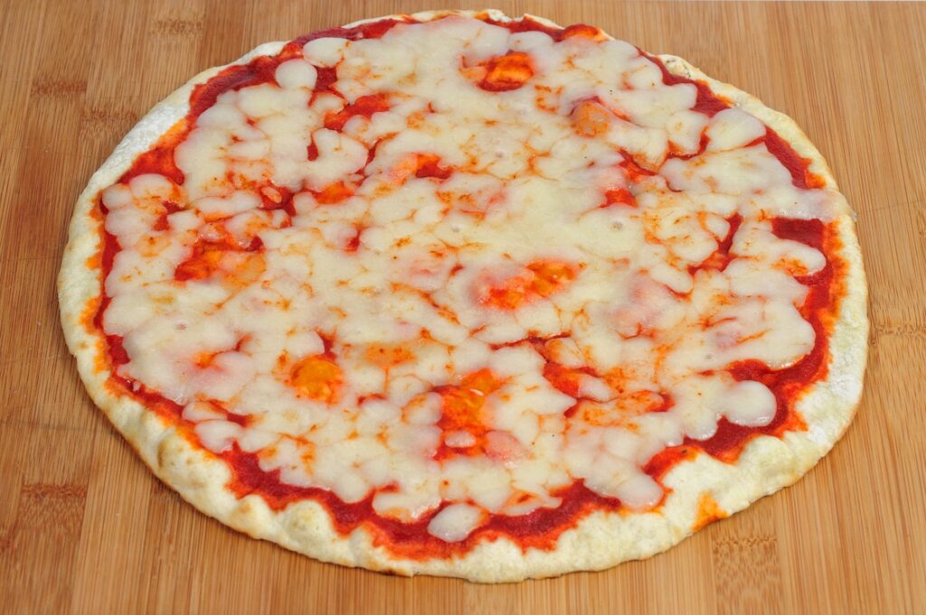 This photo shows an undercooked Margherita pizza on a wooden table.