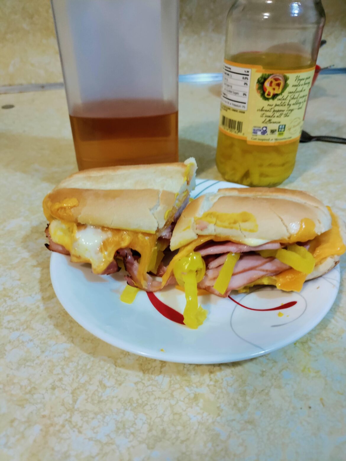 Unglamorously air fried "hoagie" with ham, cheddar, and banana peppers. Mustard topping. Whiskey induced.