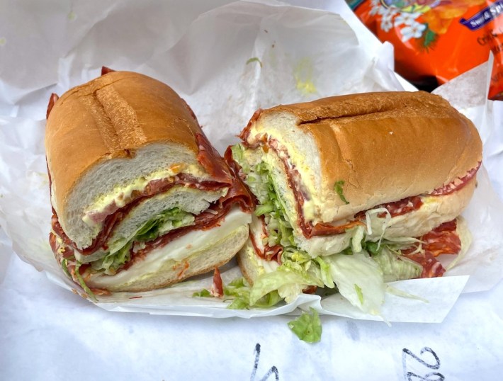 the cross-section of a sandwich with salami and oven-roasted chicken with balsamic vinegar and olive oil, LTO, mustard, mayonnaise, and mozzarella cheese