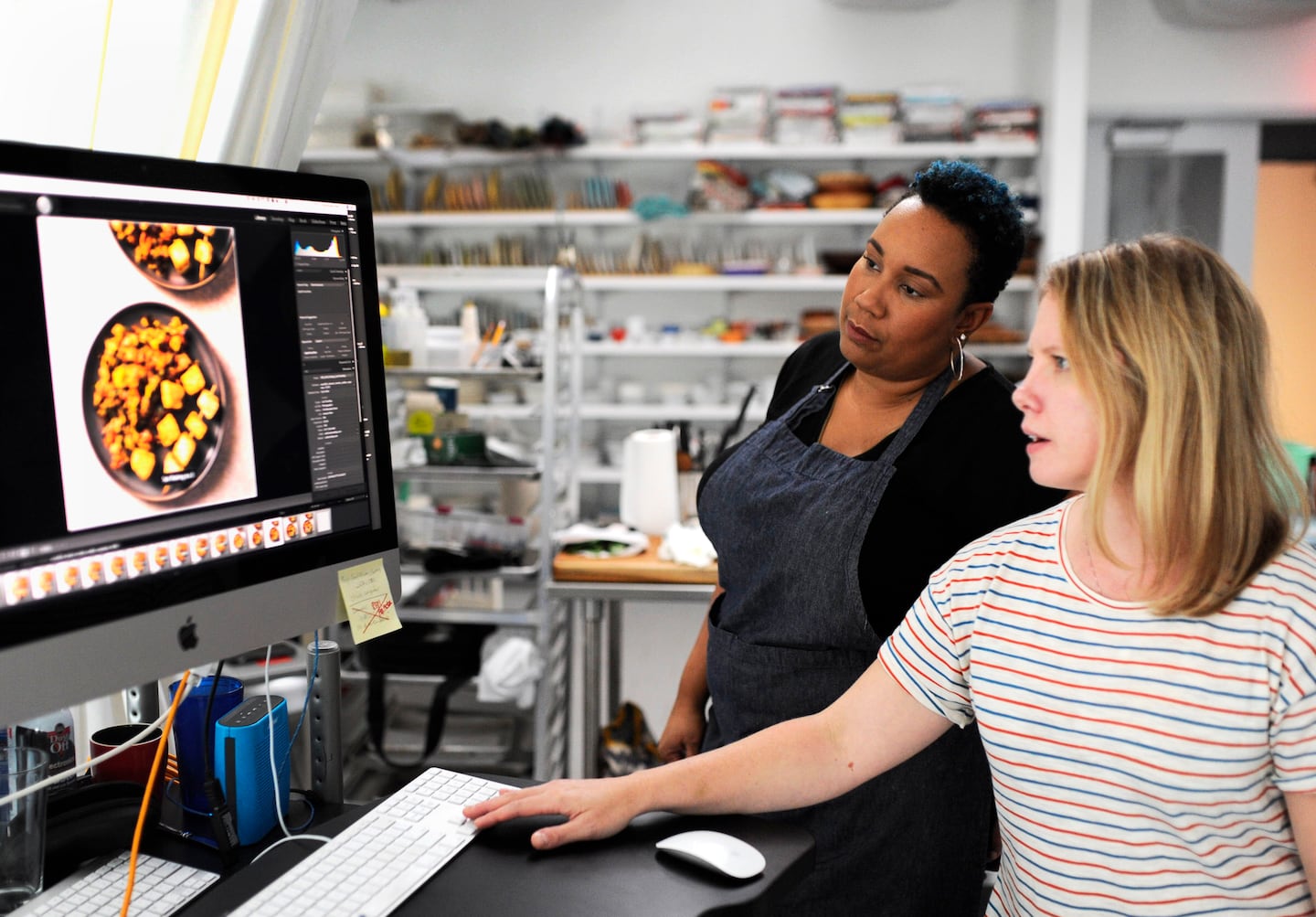 Elle Simone Scott looks over photographs of food she styled on set at America's Test Kitchen in 2018.