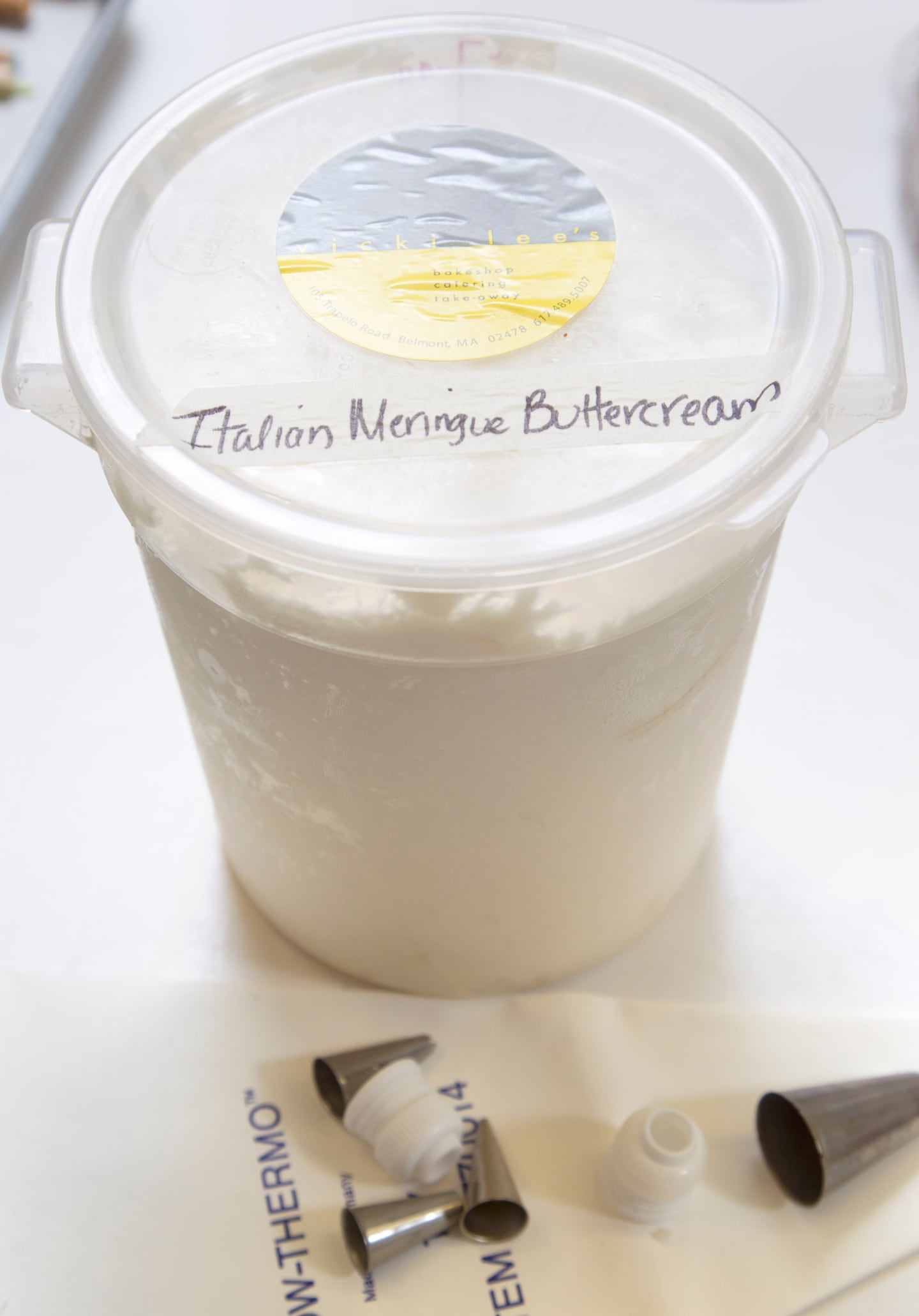 Belmont, MA - 10/03/2012 - This is one of the containers of Italian meringue buttercream frosting that Vicki Lee Boyajian will take to California. Vicki Lee Boyajian of Vicki Lee's in Belmont is wrapping up a "framboise" silver white cake with Italian meringue buttercream frosting that will serve 160 people to a wedding in Carmel, CA. She will take the cake components with her on her flight to CA. Topic: 17cake . Story by Katherine Hysmith/Globe Correspondent. Dina Rudick/Globe Staff.