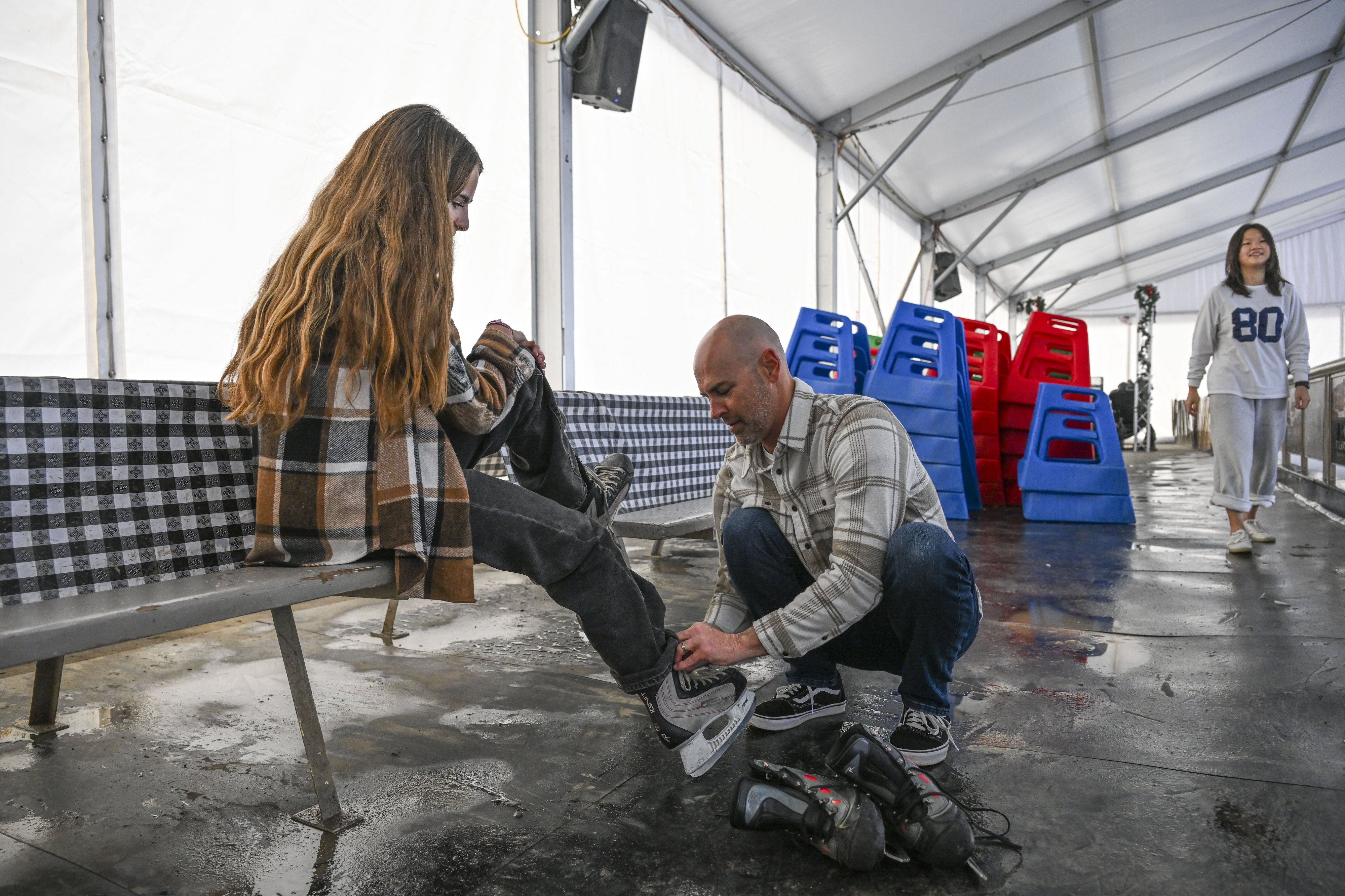 Jason Eldridge ties his daughter Keira Eldridgeâs ice skates as...