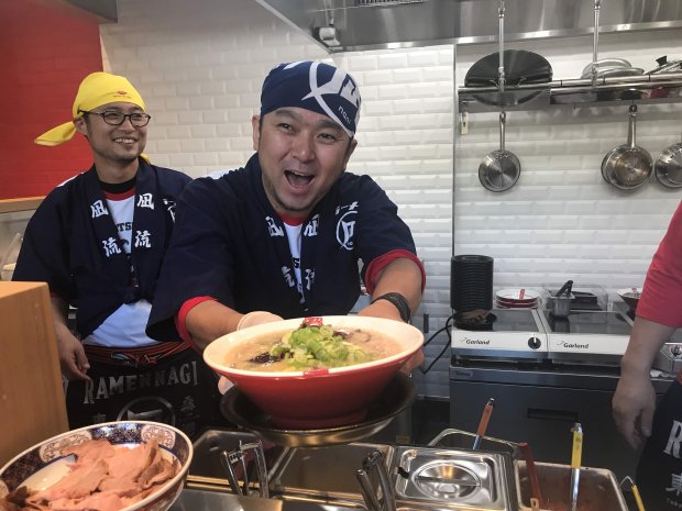 Ramen Nagi founder and chef Satoshi Ikuta presents a bowl of Original King ramen at the opening of his first U.S. restaurant in Palo Alto in 2018. (Mary Orlin/Bay Area News Group)