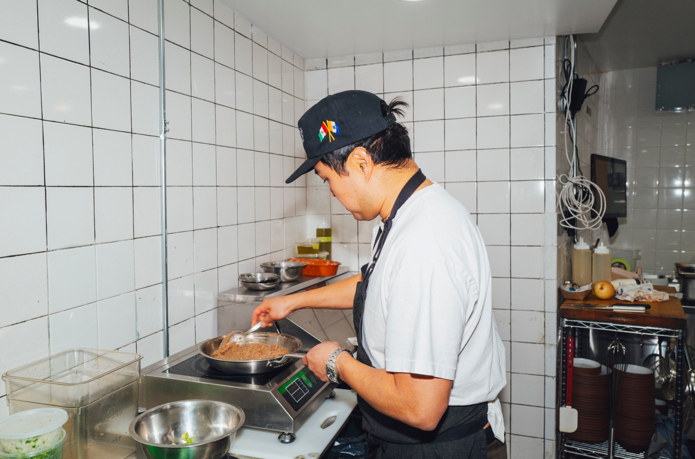A chef in the kitchen making refried beans.