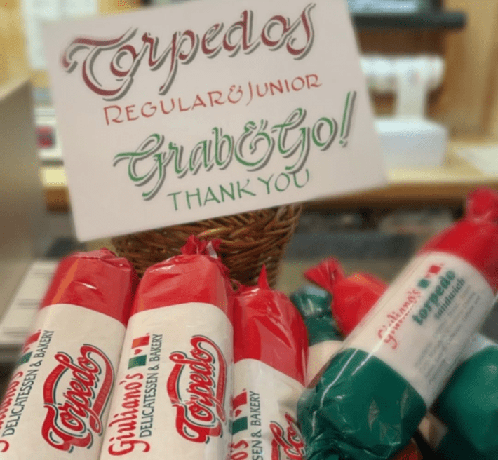 sandwiches packed in red, white, and green plastic under a "Grab&Go" sign
