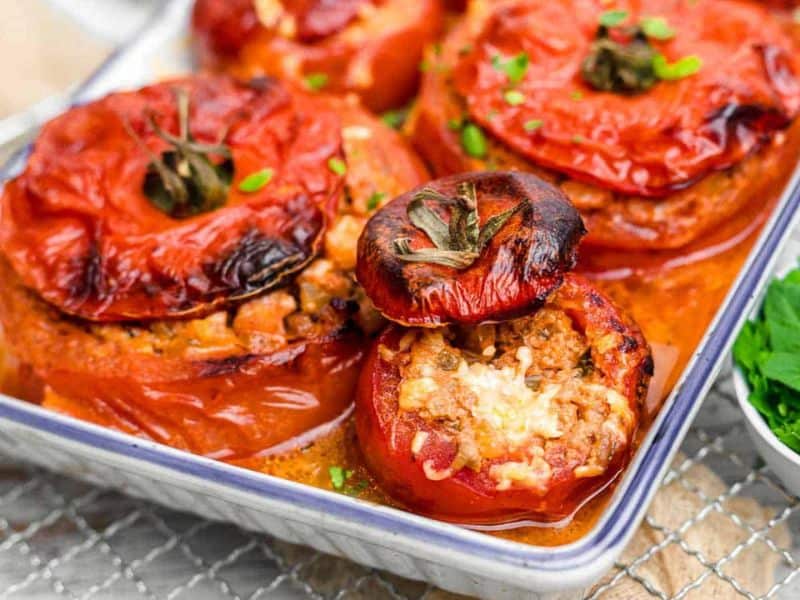 Stuffed Tomatoes inside white casserole.