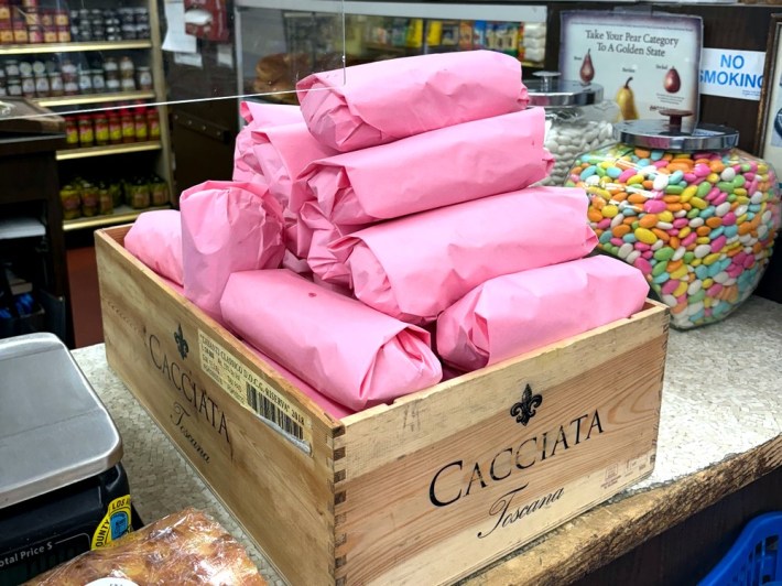 a box packed full of sandwiches wrapped in pink paper