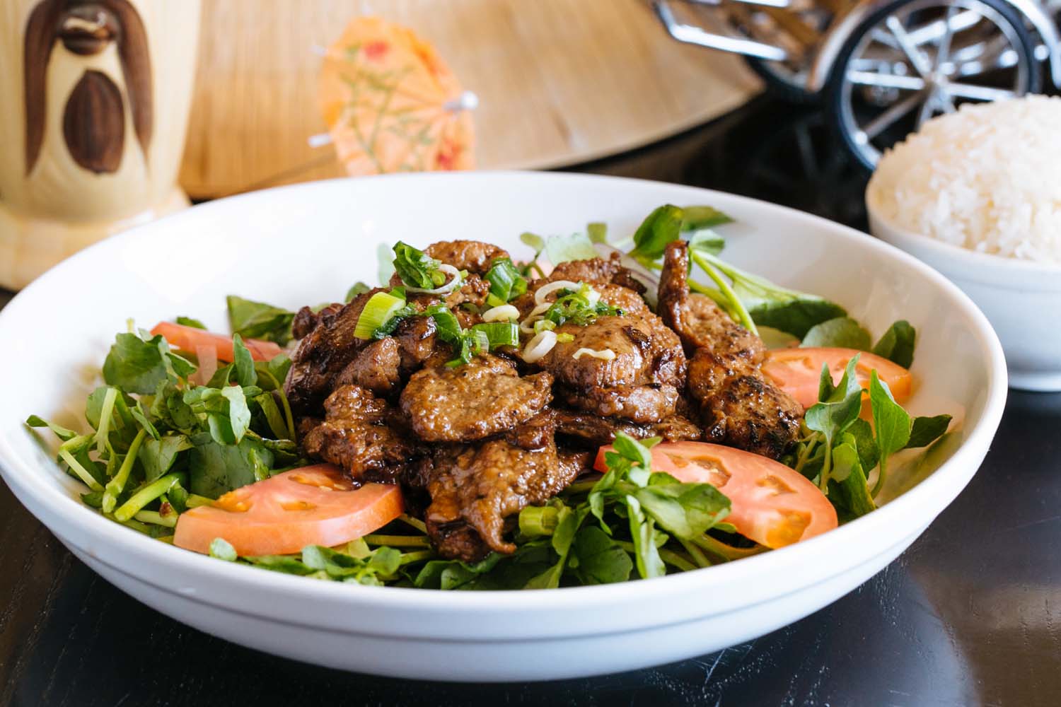bowl of greens, tomatoes, and chunks of meat 
