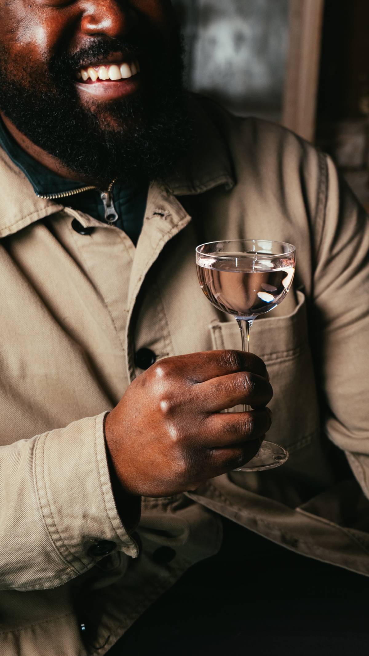 someone holding a drink in a delicate martini-style cocktail glass