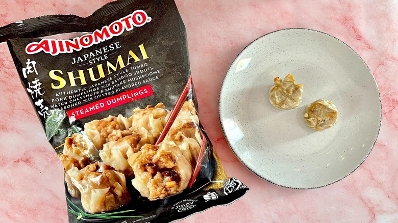 Ajinomoto Japanese Style Shumai on white plate next to bag, on pink marble surface