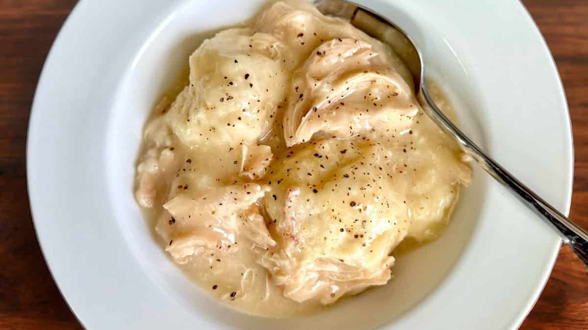 Lanie Smith's biscuit chicken and dumplings in a bowl with spoon on table.