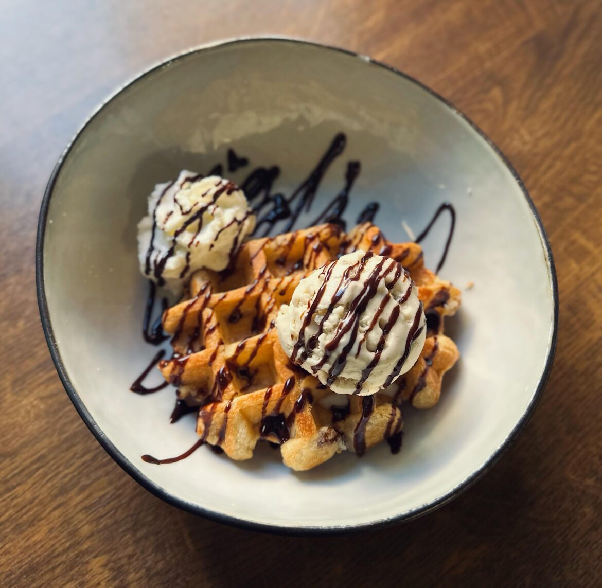 Warm waffle with ice cream and whipped cream