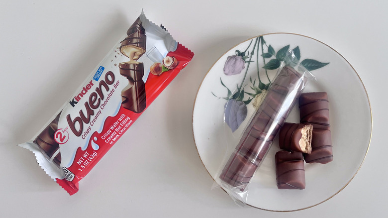 Two pack of Kinder Bueno chocolate and hazelnut chocolate bars on a plate next to a plastic wrapper