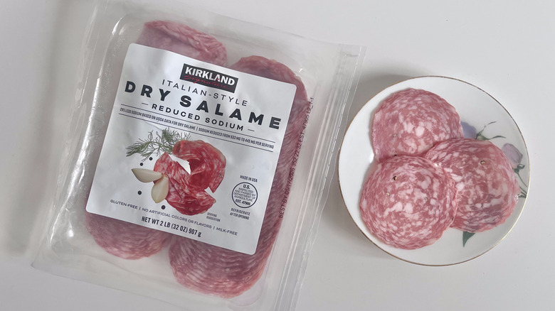 Pieces of Kirkland Signature Italian style dry salame on a plate with a packet of salame on the side