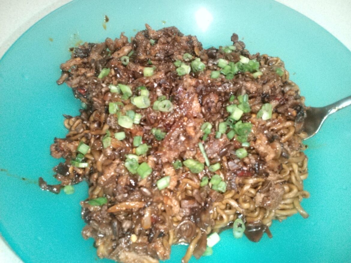 Chapagetti topped with gochujang glazed beef, onion, and mushroom