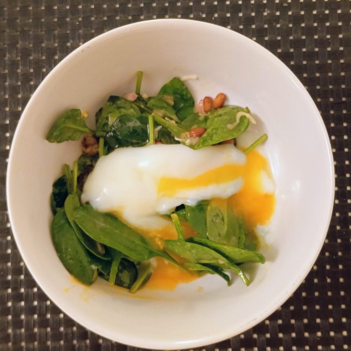 Sous vide "Onsen Egg" on top of spinach salad with capers, pine nuts and vinaigrette dressing