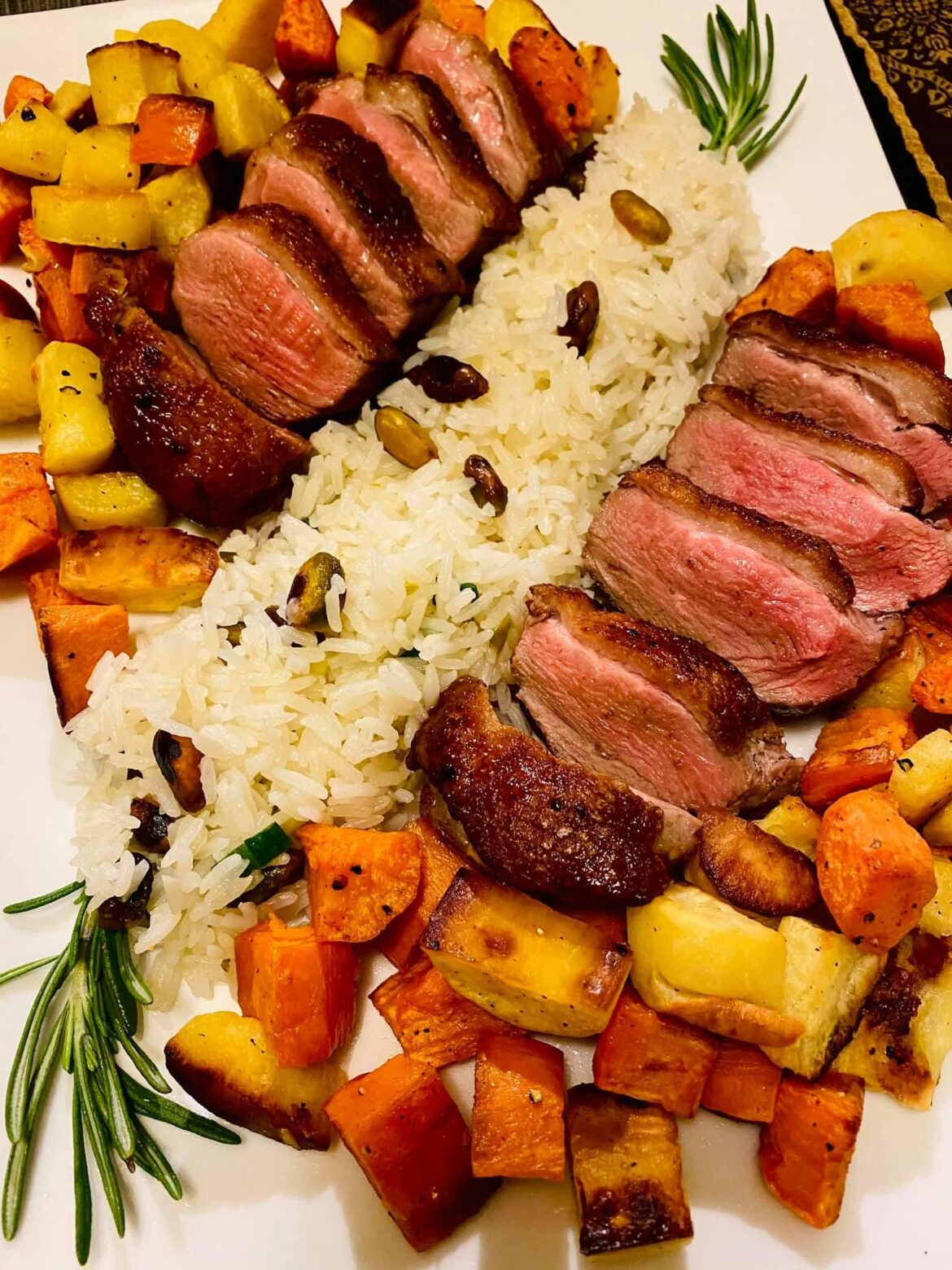 Pan-fried duck breast in cherry jam sauce, rice, roasted sweet yams and potatoes