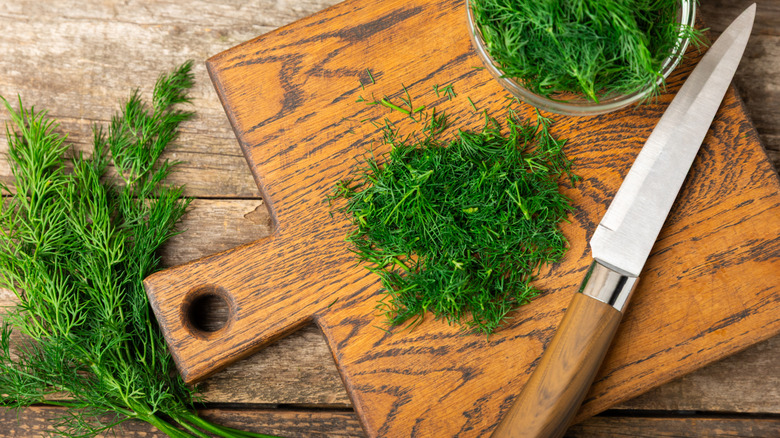 Freshly chopped dill on a wooden cutting board
