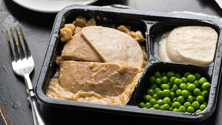 A frozen dinner tray has compartments for turkey, peas, and mashed potatoes.