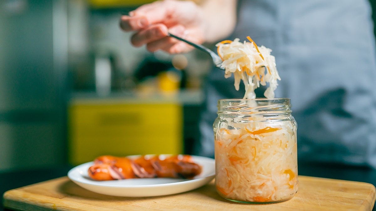 Close-up of a fork with sauerkraut and a piece of Bavarian sausage, traditional German dish