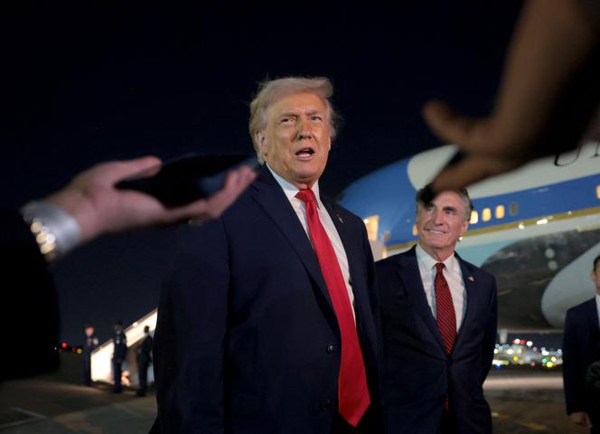 Donald Trump talks with reporters as US Secretary of the Interior Doug Burgum looks on at Palm Beach International Airport, West Palm Beach, Florida, January 19, 2026.