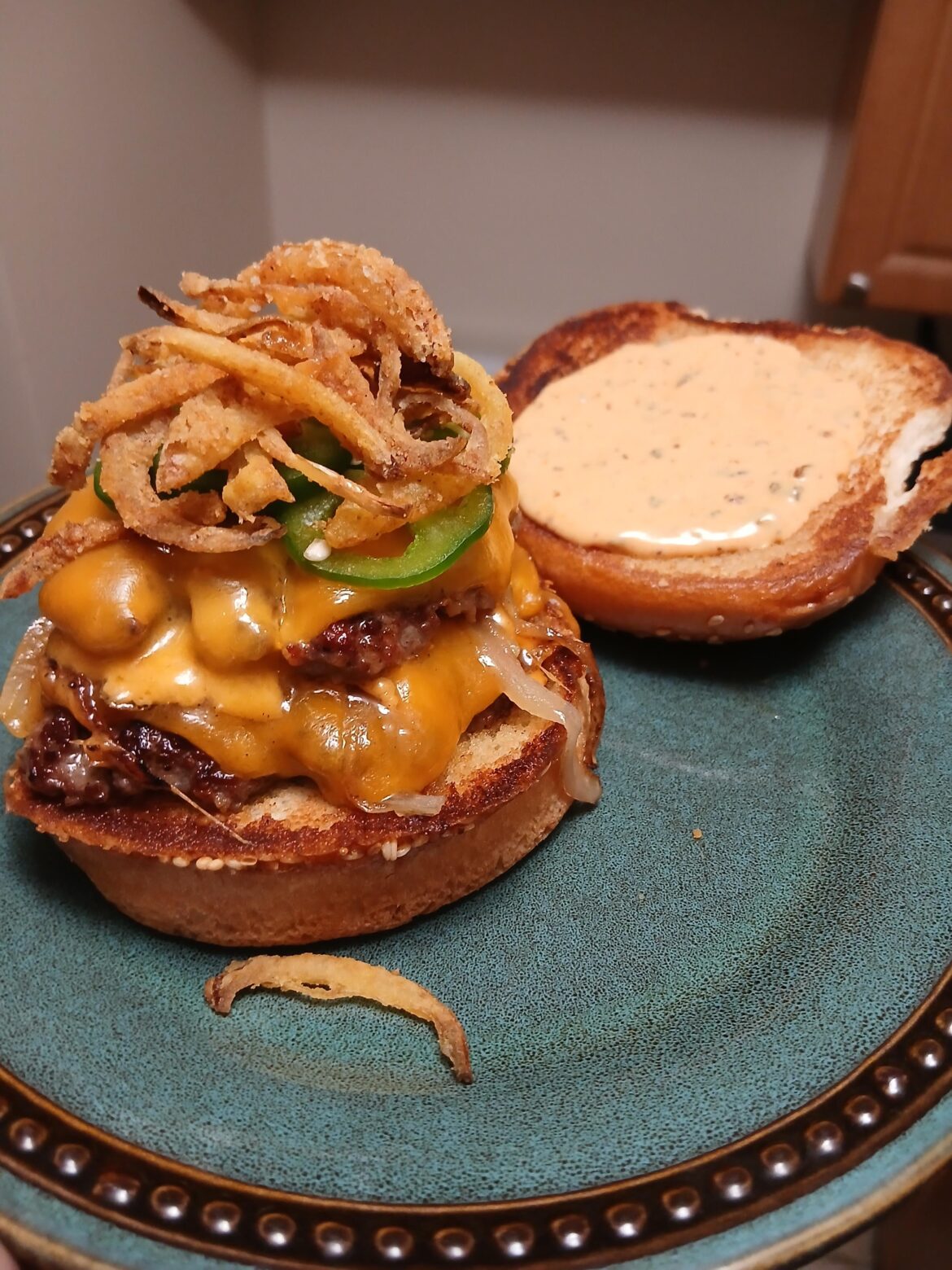 Double cheese burger with fried onions and jalapeños
