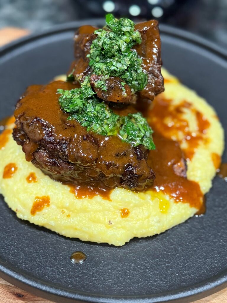 Wine Braised Short Ribs over a Cheesy and Creamy Polenta topped with its Strained and Reduced Sauce and Gremolata