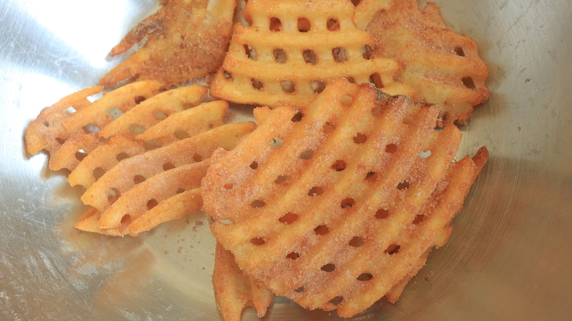 Waffle fries dusted with powdered sugar.