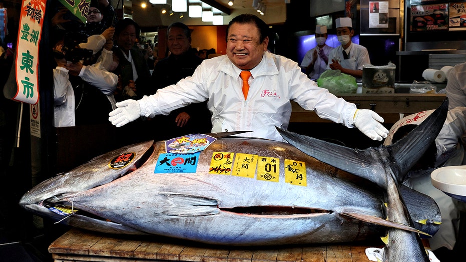 Kiyomura Co.'s President Kiyoshi Kimura standing behind massive bluefin tuna