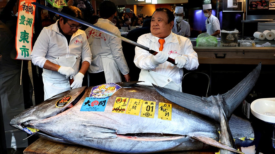 Kiyomura Co.'s President Kiyoshi Kimura standing behind massive bluefin tuna