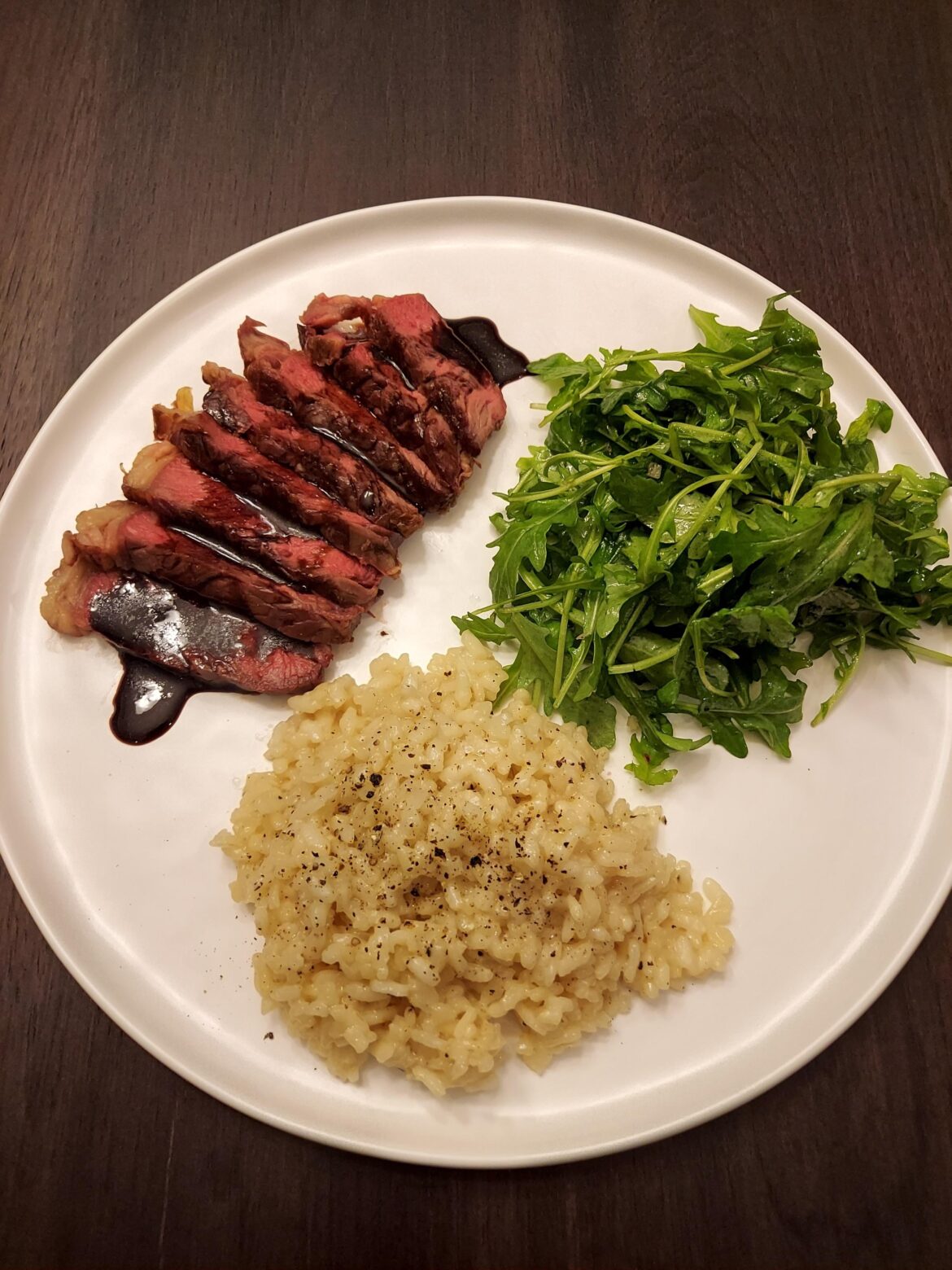 Ribeye with truffle merlot reduction, risotto parmiganio, and arugula with a mustard vinaigrette