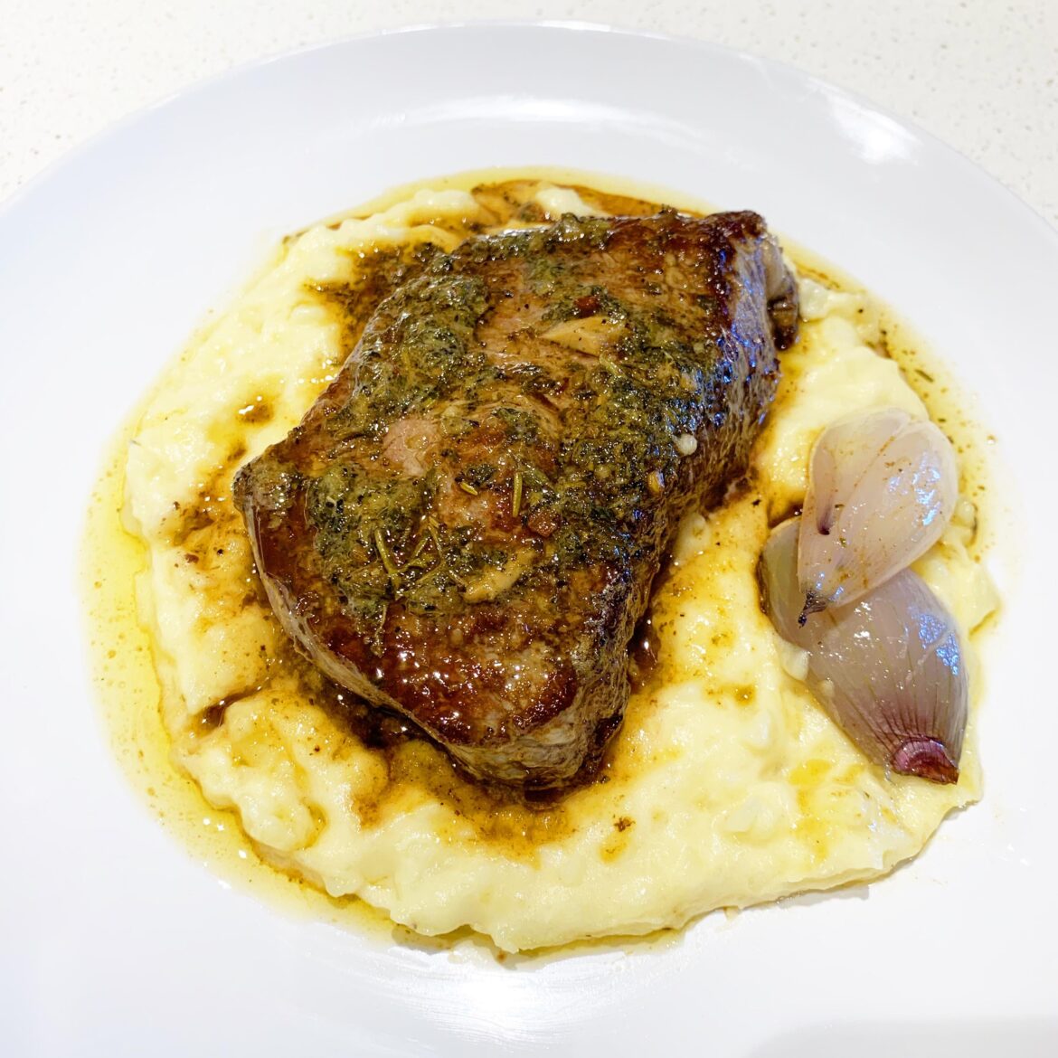 Pan-Seared Steak with Bone Marrow Herb Butter & Roasted Shallots on Creamy Mashed Potatoes
