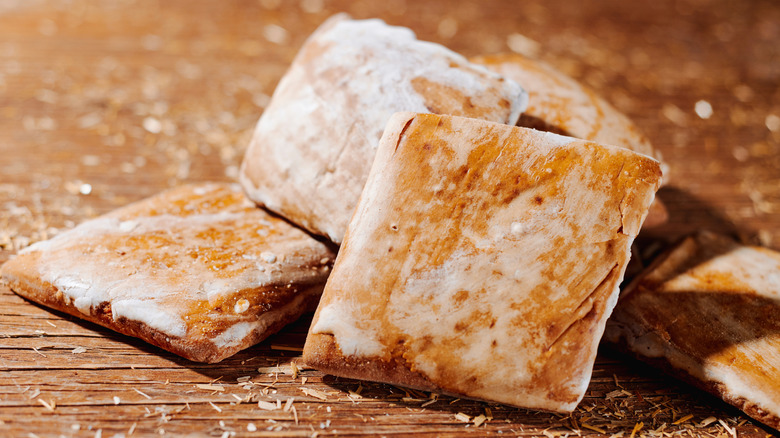 Lightly glazed mostaccioli cookies on a wooden table