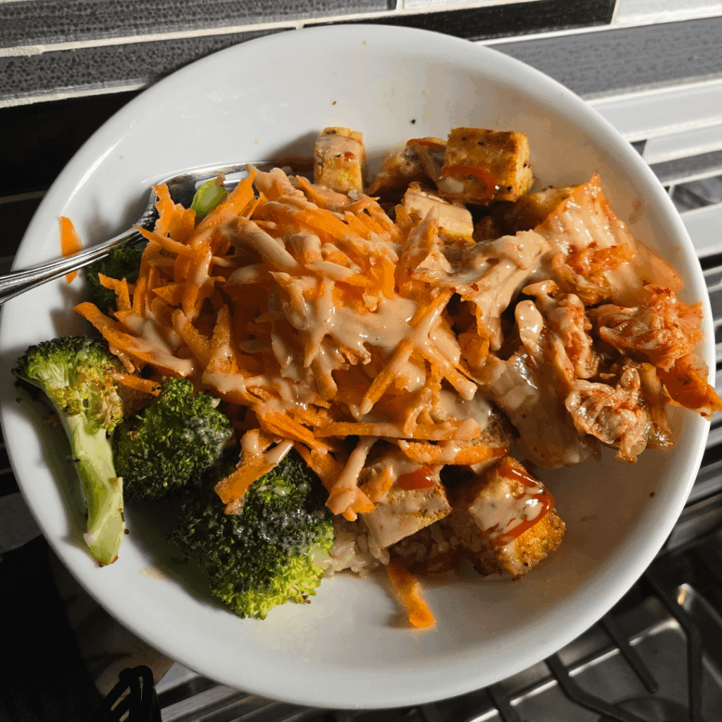 Baked tofu&broccoli brown rice bowl. Topped with kimchi, grated carrots, sriracha, tahini, sunflower seeds and hemp hearts.
