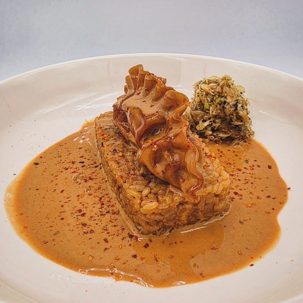 Bulgogi mandu curry cream on beef broth/marrow rice with quick-pickled cabbage: urfa biber, fish salt, sesame oil, and black vinegar