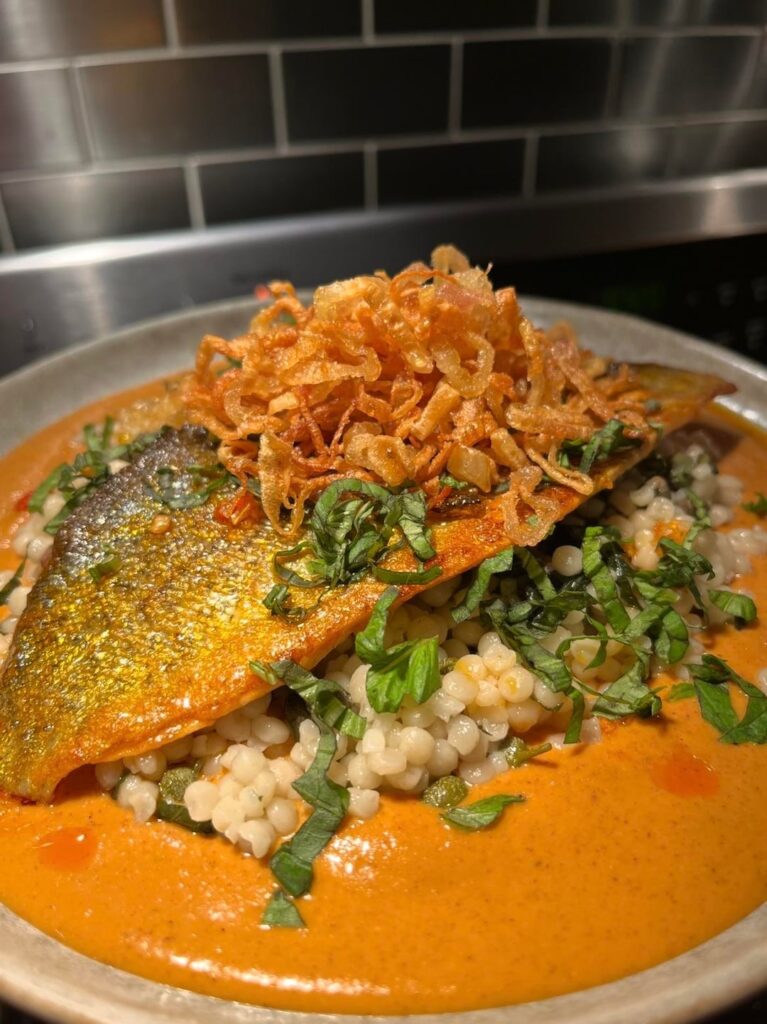 Rainbow Trout, couscous, romesco, Calabrian chili oil, crispy shallots