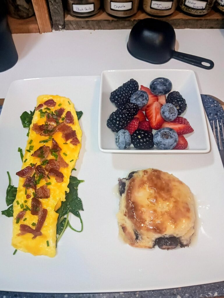 Homemade blueberry biscuits and an omelet with spinach, cheese and bacon.
