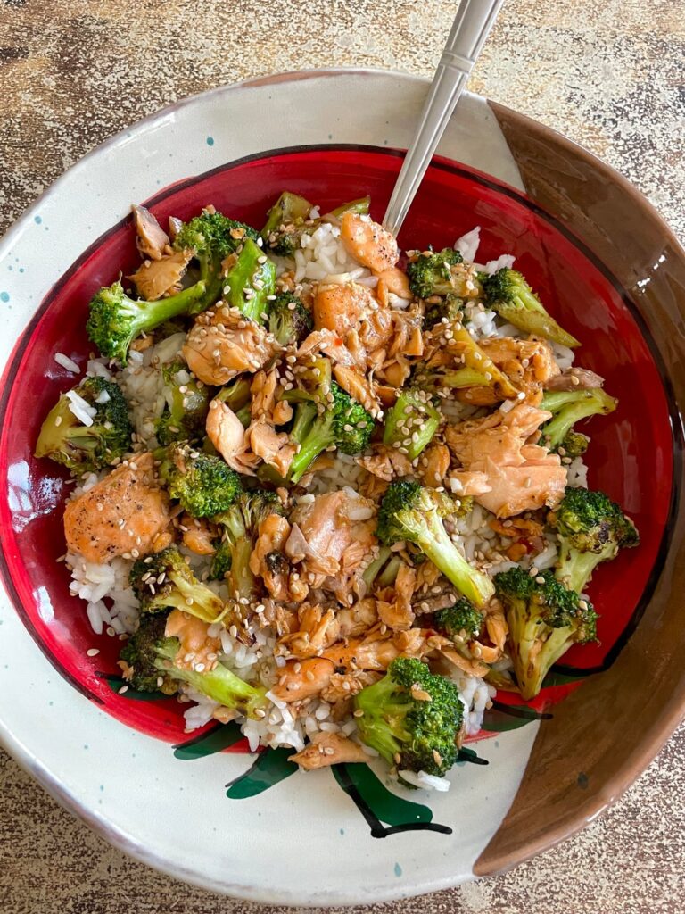 Salmon & broccoli coated in stir fry sauce on a bed of white rice 🍚🥦🍣