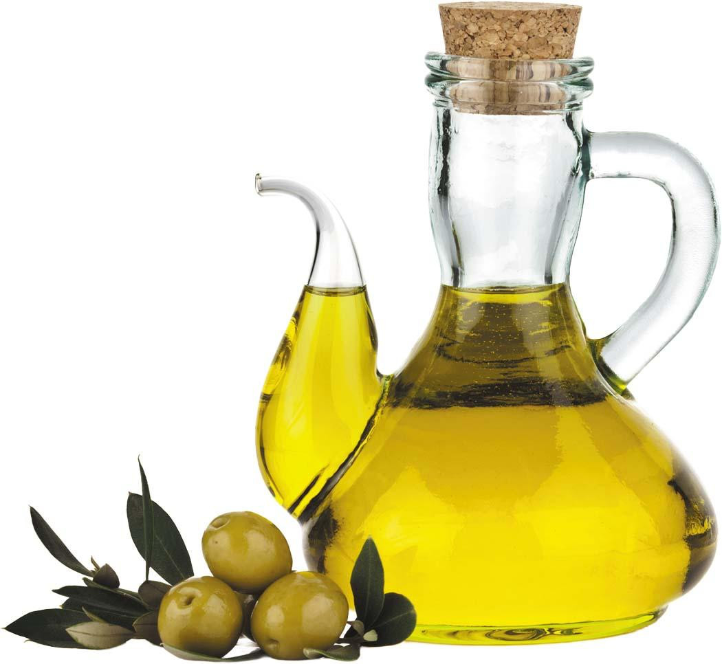 A glass pitcher of olive oil with a cork stopper next to three green olives still attached to a branch.