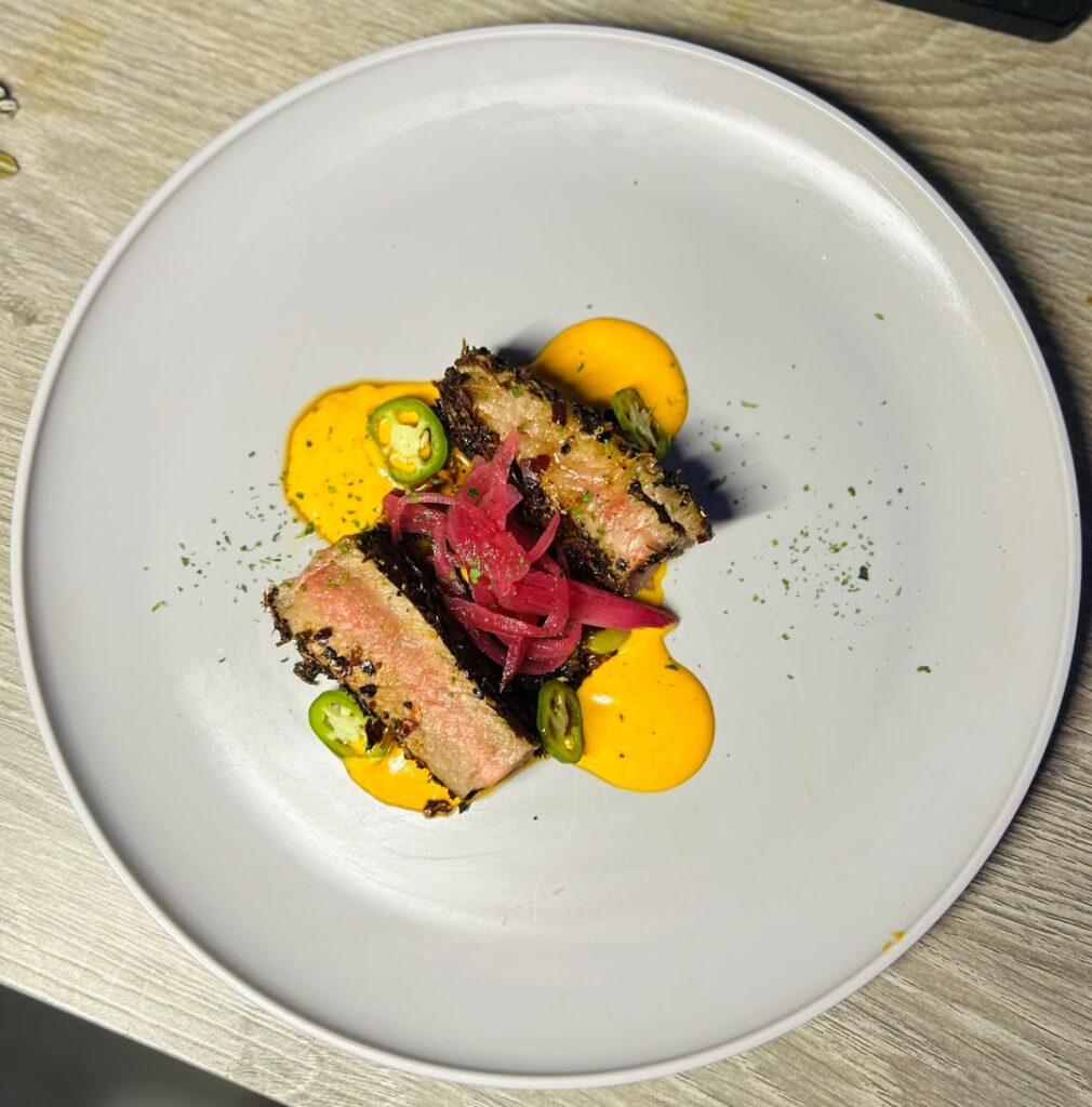 Ancho,Guajillo, and costeƱo crusted ny strip, aji aioli, pickled onions Ancho,Guajillo, and costeƱo crusted ny strip, aji aioli, pickled onions