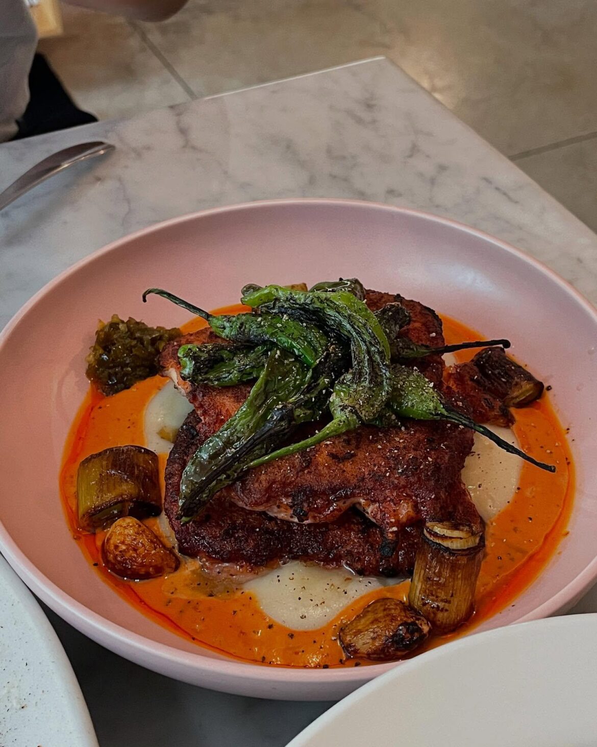 Perfectly seared chicken with charred shishito peppers. A flavor explosion