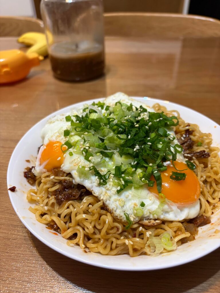 Ramen served with leftover barbacoa meat from taco night, two sunny side eggs, healthy portion of green onions, sesame seeds, sesame oil, and chili crisp. It’s not a looker but it tasted amazing 🍜✨