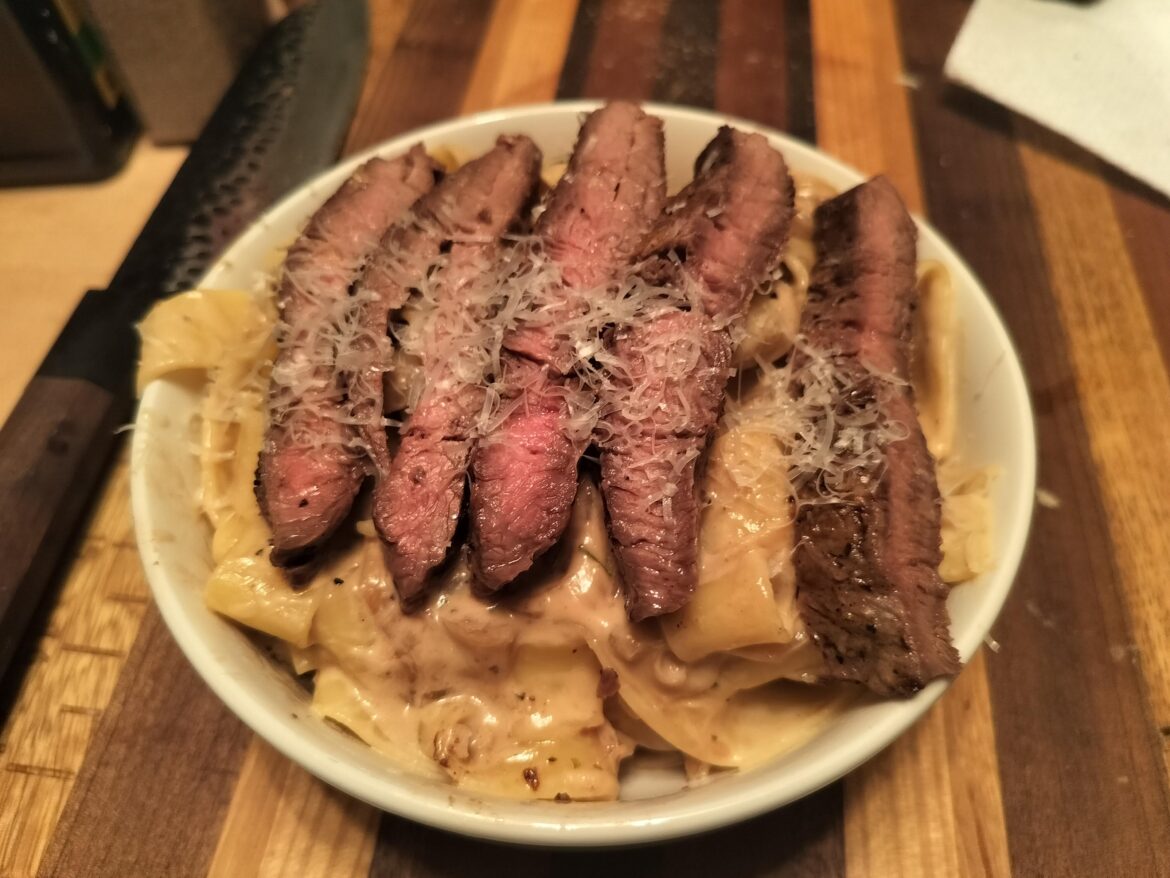 Carmalized onion cream sauce, pappardelle pasta and a flat iron steak on top
