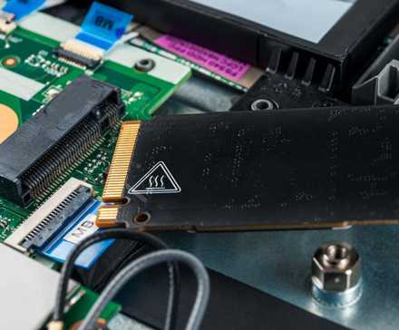 A laptop SSD with a heat warning label on the other side.