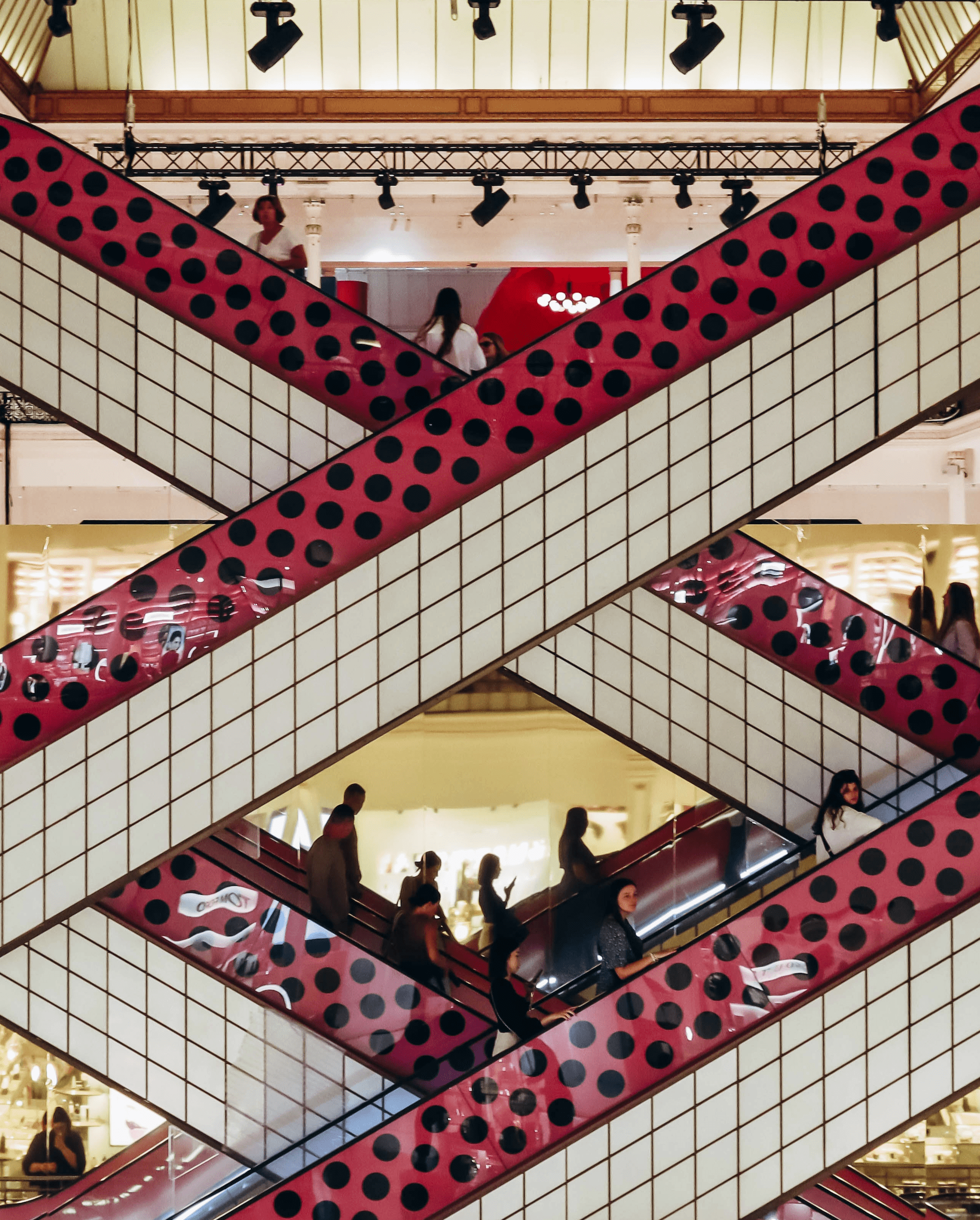 Shoppers on colorful, crisscrossing escalators.